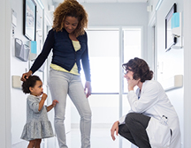 Doctor talking to Young girl with mother besides